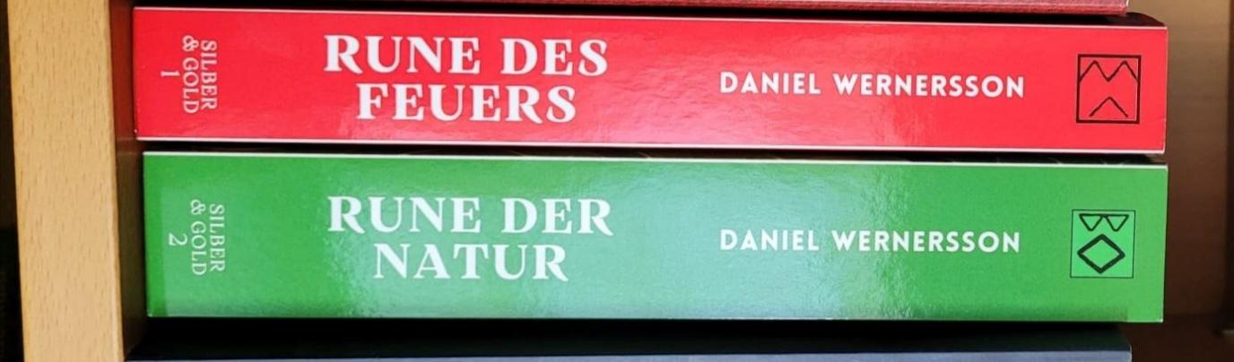 Die Buchrücken der Bücher Rune des Feuers und Rune der Natur in Rot und Grün aufeinanderliegend